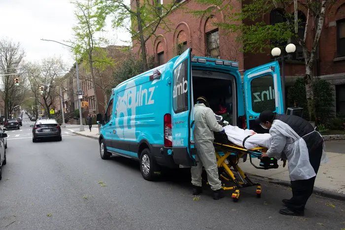 Ambulance workers pickup an elderly man from Cobble Hill Health Center.